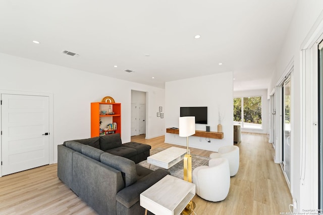 living room with light wood-style floors, recessed lighting, and visible vents