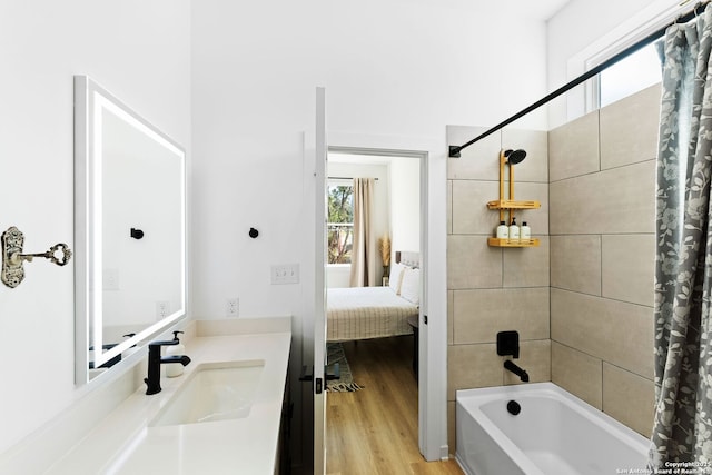 ensuite bathroom featuring shower / bath combo with shower curtain, vanity, ensuite bathroom, and wood finished floors