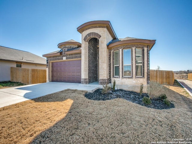 view of front of property with a garage, stone siding, driveway, and fence