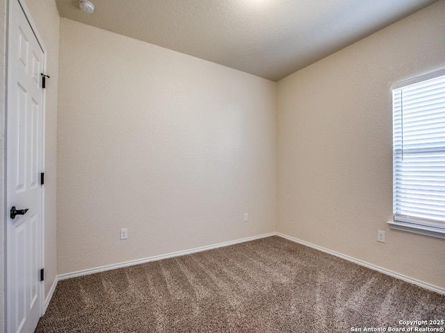 carpeted spare room with baseboards