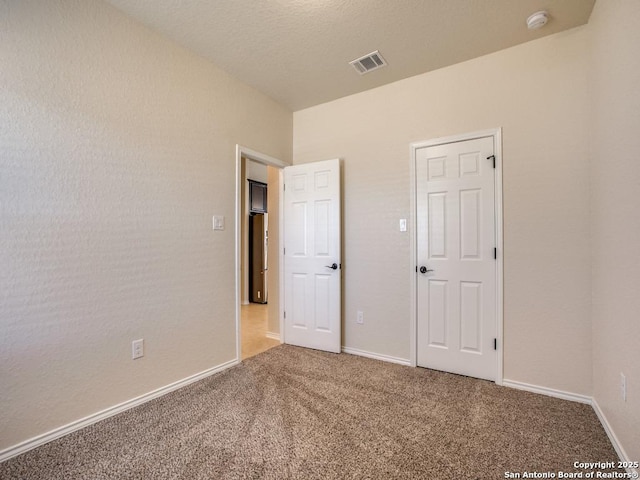 unfurnished bedroom featuring carpet, visible vents, and baseboards