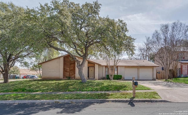 view of front facade with a garage, driveway, and a front lawn