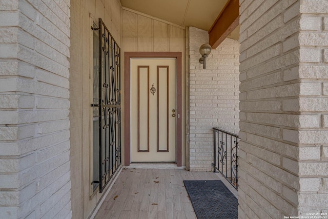 doorway to property featuring brick siding