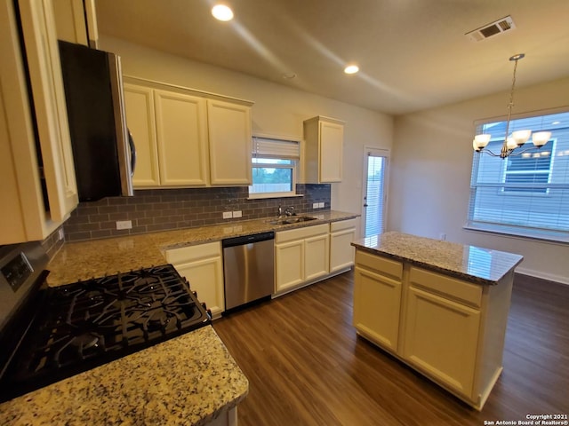 kitchen with visible vents, decorative backsplash, dark wood-style floors, appliances with stainless steel finishes, and a sink