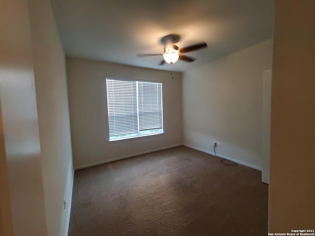 carpeted empty room featuring ceiling fan and baseboards