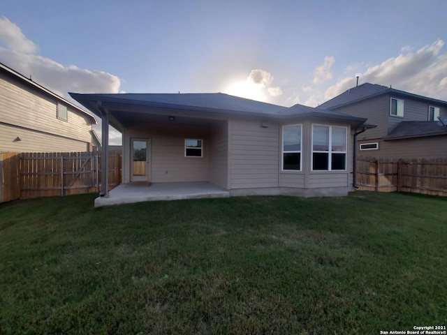 back of house with a fenced backyard, a yard, and a patio