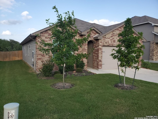 view of front of property featuring driveway, an attached garage, fence, a front lawn, and brick siding