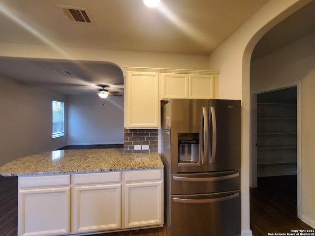 kitchen with stainless steel refrigerator with ice dispenser, visible vents, decorative backsplash, white cabinetry, and ceiling fan