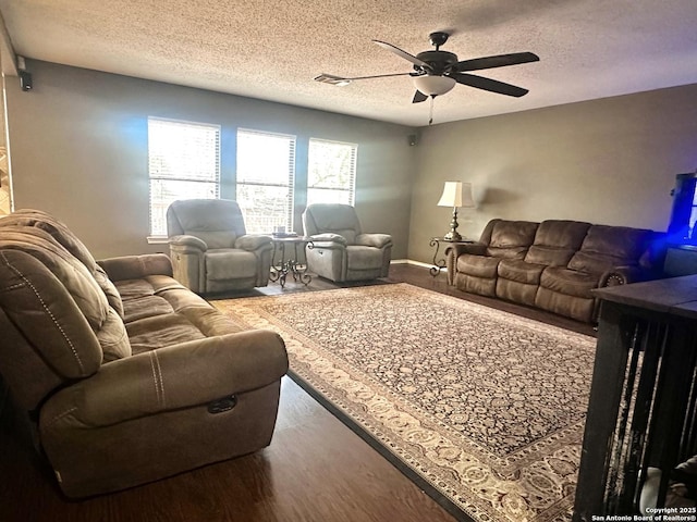 living area featuring a textured ceiling, a ceiling fan, and wood finished floors