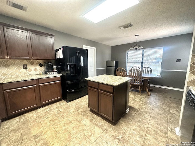 kitchen featuring an inviting chandelier, visible vents, black refrigerator with ice dispenser, and freestanding refrigerator