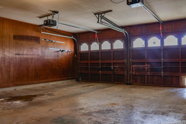 garage with wood walls and a garage door opener