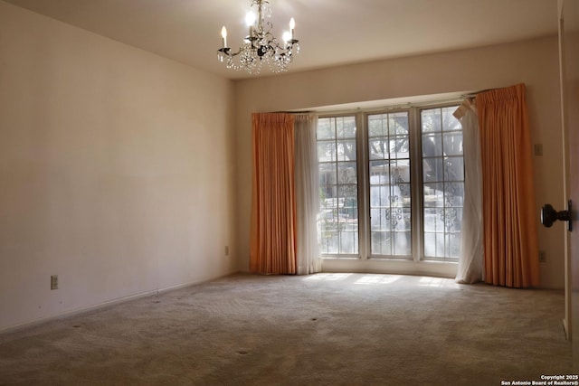 empty room with an inviting chandelier, a wealth of natural light, and carpet flooring