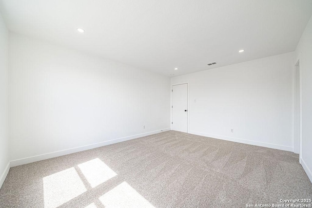 carpeted spare room with recessed lighting, visible vents, and baseboards