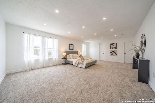 bedroom featuring recessed lighting, baseboards, a textured ceiling, and light colored carpet