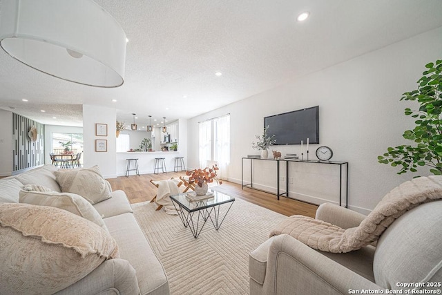 living area with wood finished floors, a wealth of natural light, and recessed lighting