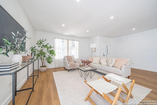 living area featuring recessed lighting, baseboards, and wood finished floors