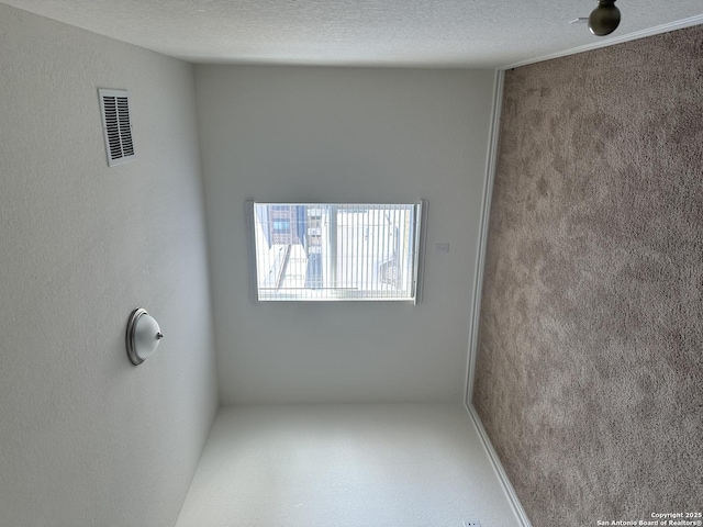 unfurnished room featuring a textured ceiling and visible vents