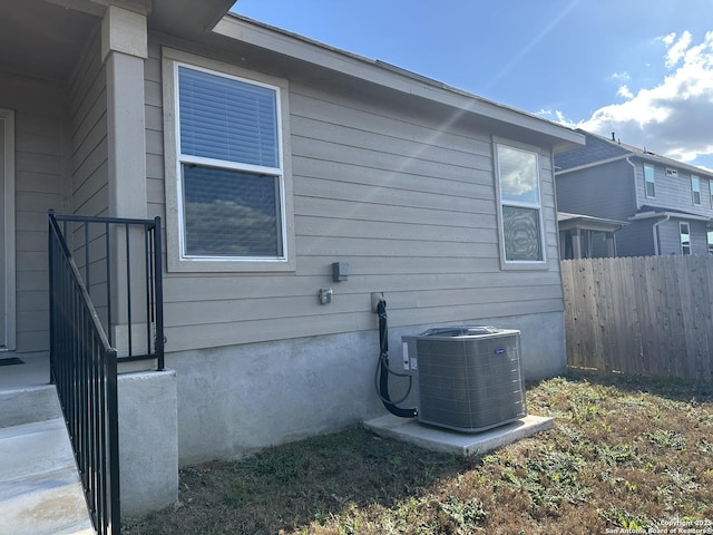 view of home's exterior with fence and cooling unit