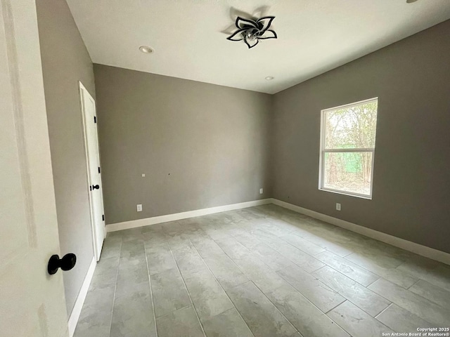 unfurnished room with baseboards