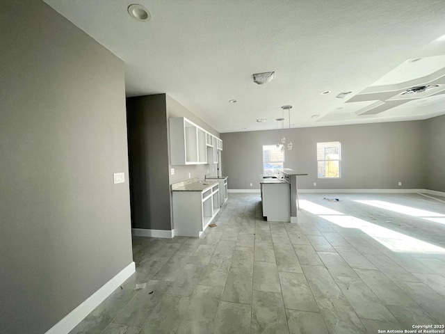 kitchen with open floor plan, baseboards, visible vents, and white cabinets