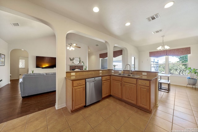 kitchen with lofted ceiling, stainless steel dishwasher, a sink, and visible vents