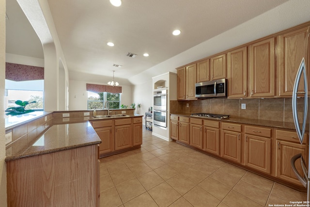 kitchen featuring tasteful backsplash, appliances with stainless steel finishes, stone countertops, light tile patterned flooring, and a sink