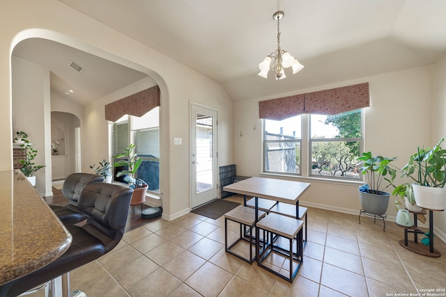 dining area with light tile patterned floors, lofted ceiling, visible vents, an inviting chandelier, and baseboards