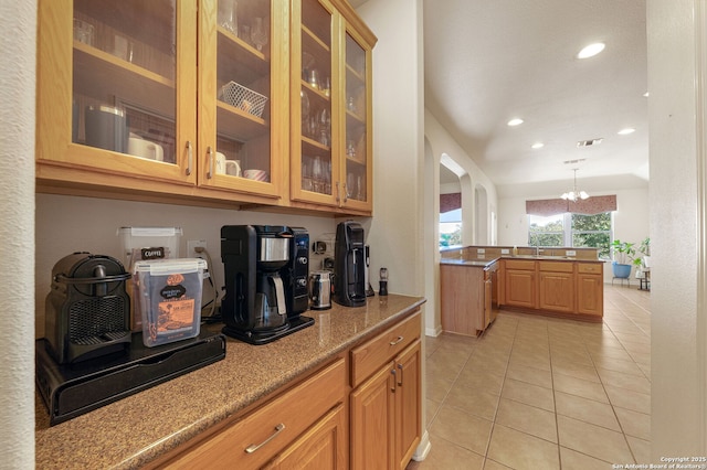 kitchen featuring arched walkways, light tile patterned flooring, recessed lighting, visible vents, and glass insert cabinets