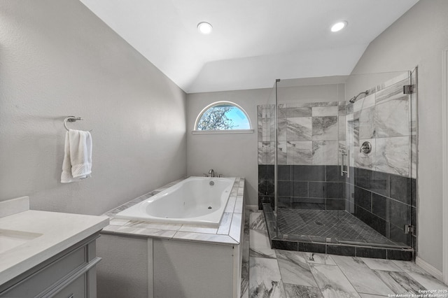 full bath featuring vanity, vaulted ceiling, marble finish floor, a jetted tub, and a stall shower