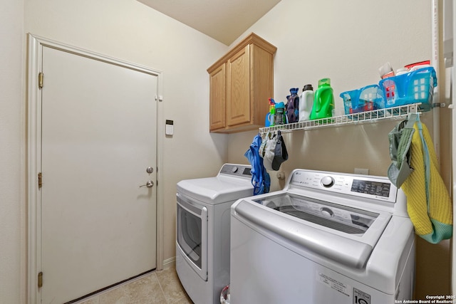 laundry room with light tile patterned floors, washing machine and dryer, and cabinet space