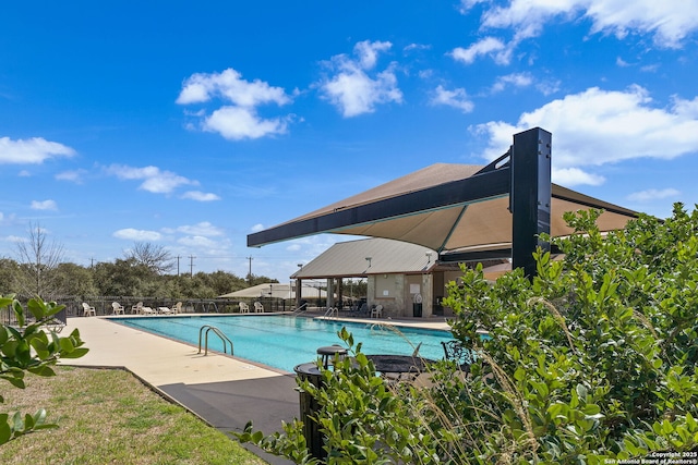 pool with a patio area and fence