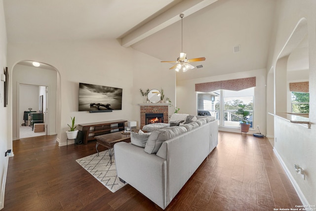 living area featuring visible vents, a brick fireplace, wood finished floors, high vaulted ceiling, and beamed ceiling