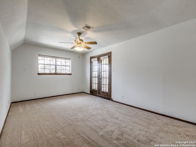 carpeted spare room featuring french doors, visible vents, a ceiling fan, a textured ceiling, and baseboards