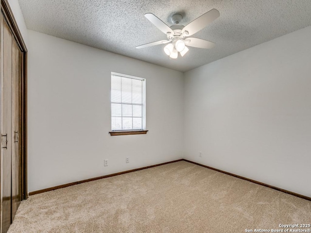 unfurnished bedroom featuring carpet floors, a closet, a textured ceiling, and a ceiling fan