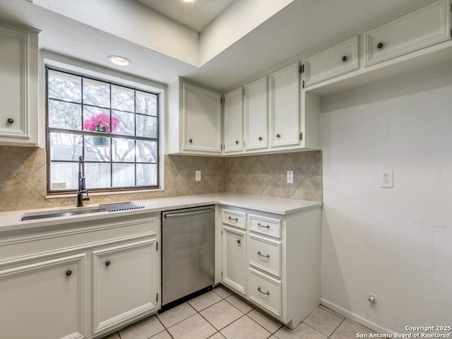 kitchen featuring light tile patterned floors, a sink, light countertops, dishwasher, and tasteful backsplash