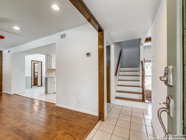 foyer with light tile patterned floors, stairs, visible vents, and recessed lighting