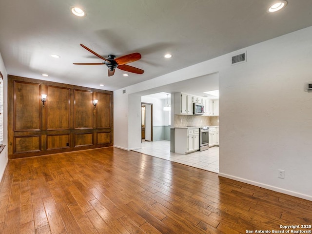 unfurnished living room with recessed lighting, visible vents, light wood-style flooring, ceiling fan, and baseboards