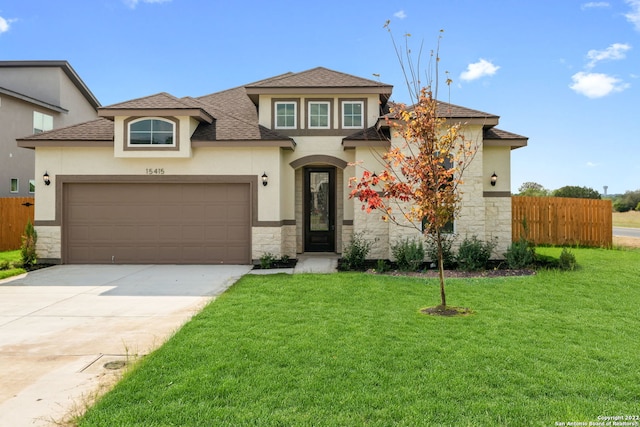 view of front facade featuring driveway, an attached garage, fence, and a front yard