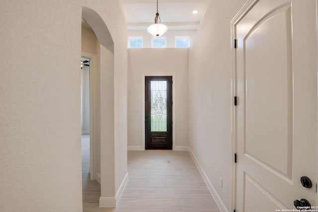 entryway featuring a wealth of natural light, arched walkways, baseboards, and recessed lighting