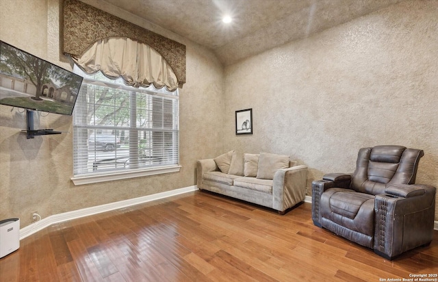 living area featuring wood-type flooring and baseboards