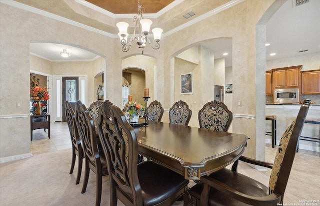 dining area featuring a chandelier, ornamental molding, and visible vents