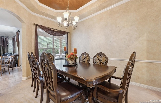 dining space with arched walkways, ornamental molding, a chandelier, and light colored carpet