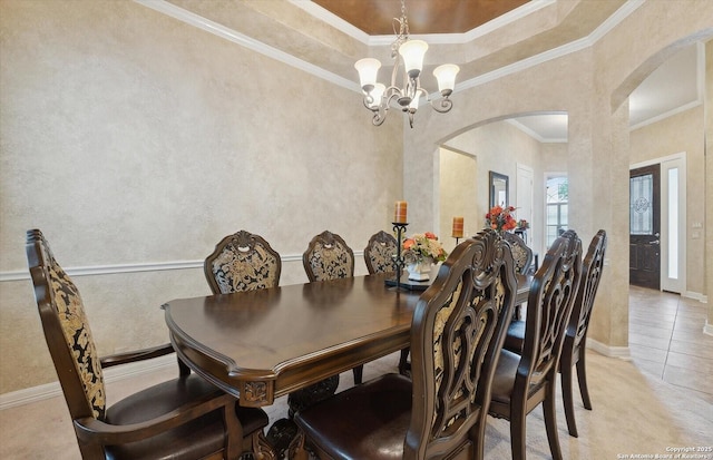 dining space with arched walkways, a textured wall, an inviting chandelier, ornamental molding, and baseboards