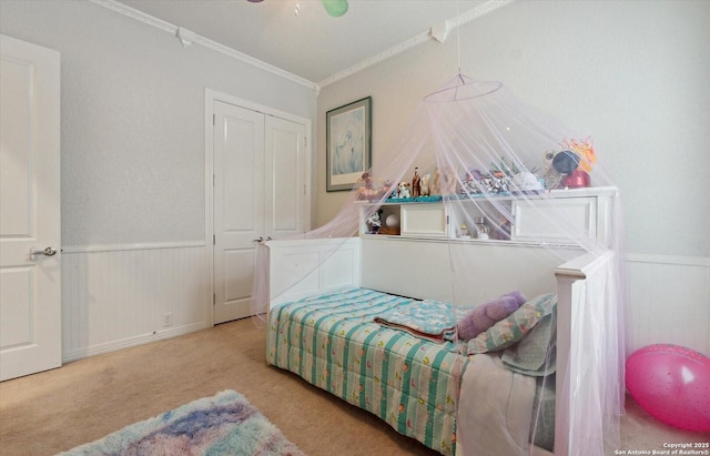 bedroom with carpet, ornamental molding, and wainscoting