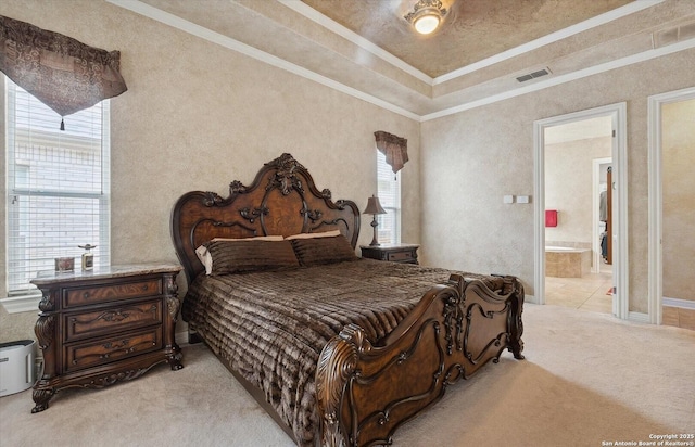 bedroom featuring visible vents, ornamental molding, connected bathroom, and light colored carpet