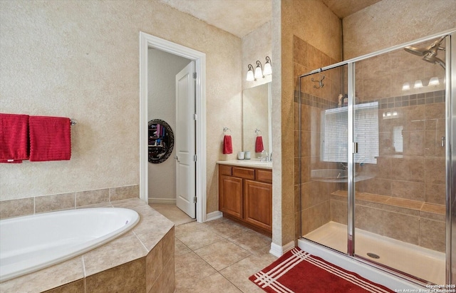 full bathroom with a bath, a stall shower, tile patterned flooring, and vanity