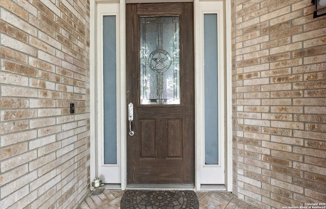 doorway to property with brick siding