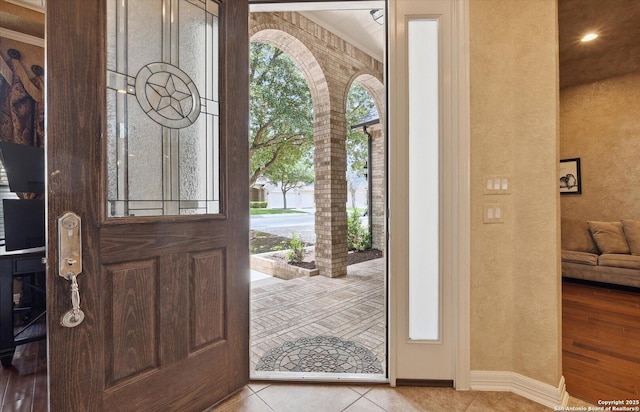 entrance foyer featuring baseboards and tile patterned floors