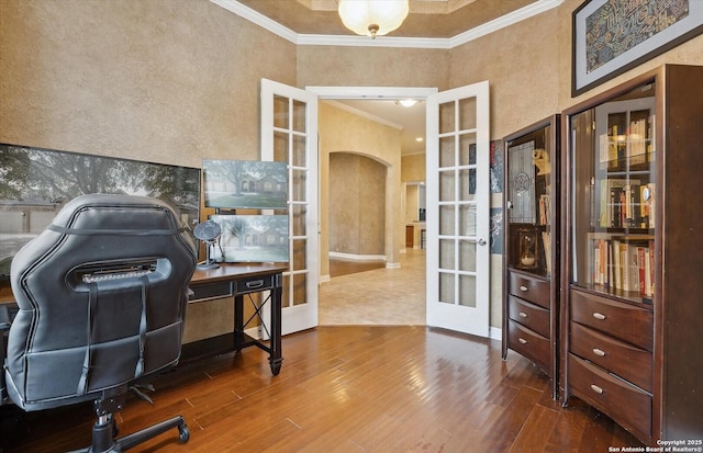 office space with crown molding, arched walkways, wood finished floors, and french doors