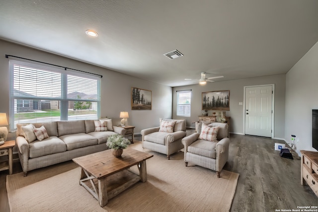 living area featuring a ceiling fan, baseboards, visible vents, and wood finished floors